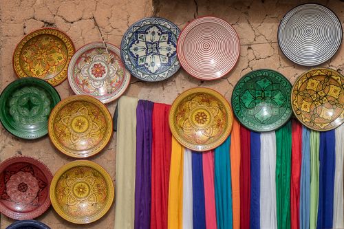Free A display of vibrant, traditional ceramic plates on an earthy, rustic wall. Stock Photo