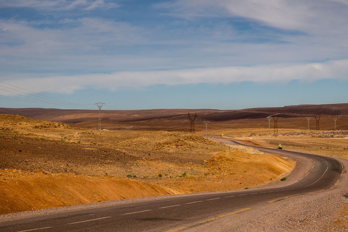 Two-lane road winding through open desert under a clear sky