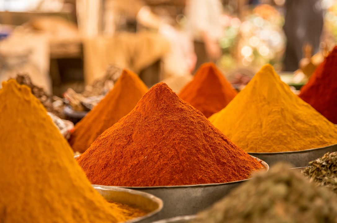 Gujarat's Vegetarian Food Heritage: Why It Leads India 2 Colourful pyramids of ground spices including turmeric and chilli powder at an Indian spice market