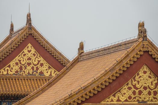 特写镜头展现了传统亚洲寺庙屋顶的复杂装饰，带有金色图案和陶土瓷砖