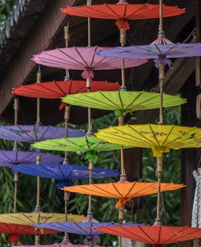 Vibrant paper umbrellas hanging as outdoor decoration, showcasing Asian cultural aesthetics.