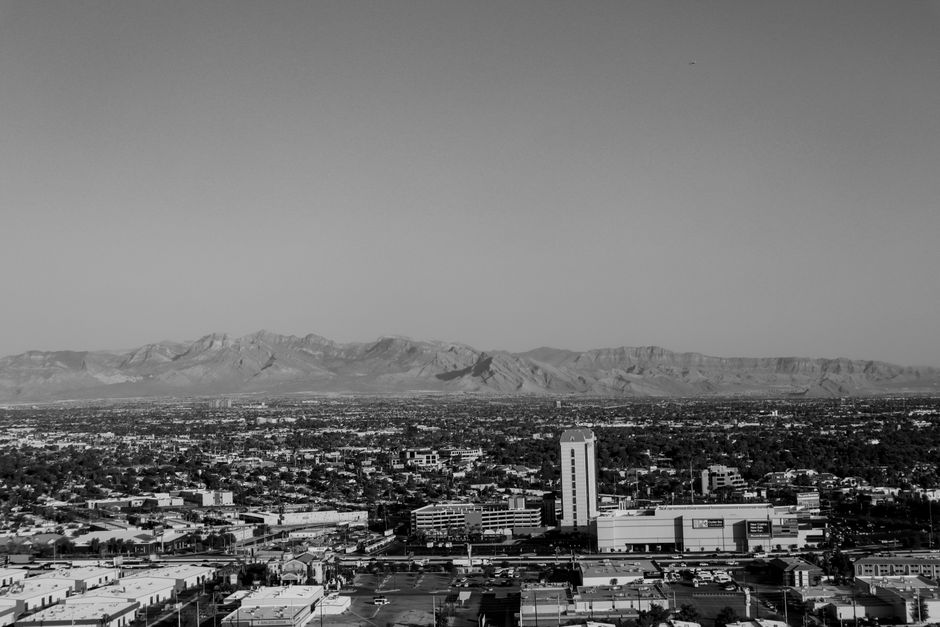 Black and white aerial shot of Las Vegas cityscape with mountains.