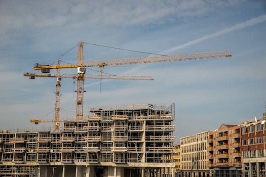City construction site with cranes and partially built structures under a clear sky.