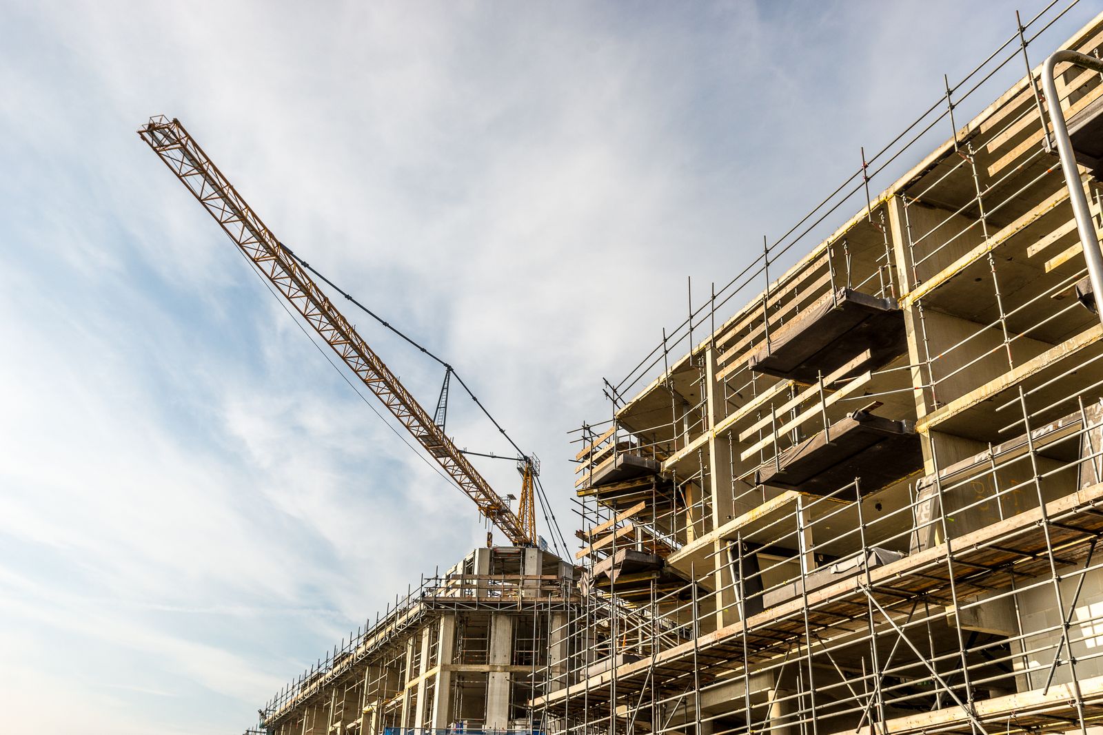 Eingerüstetes Gebäude mit Baukran – Bauen im Bestand