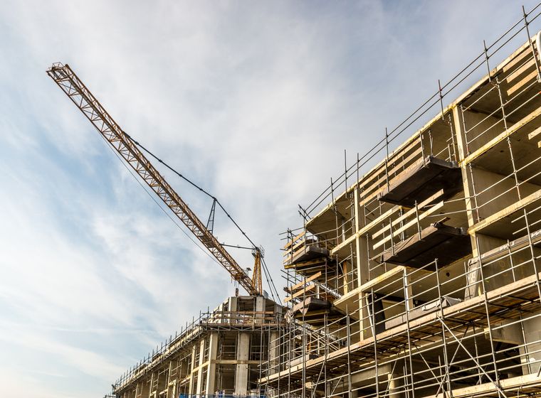 Commercial construction site with crane and structural work