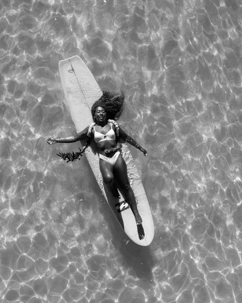 A Woman Lying Down on a Surf Board