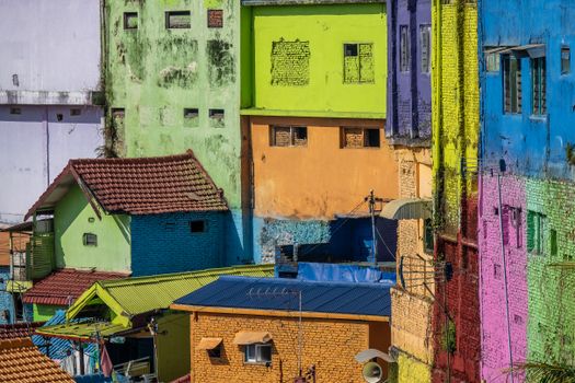 Brightly colored urban houses with vibrant painted facades create a lively cityscape.