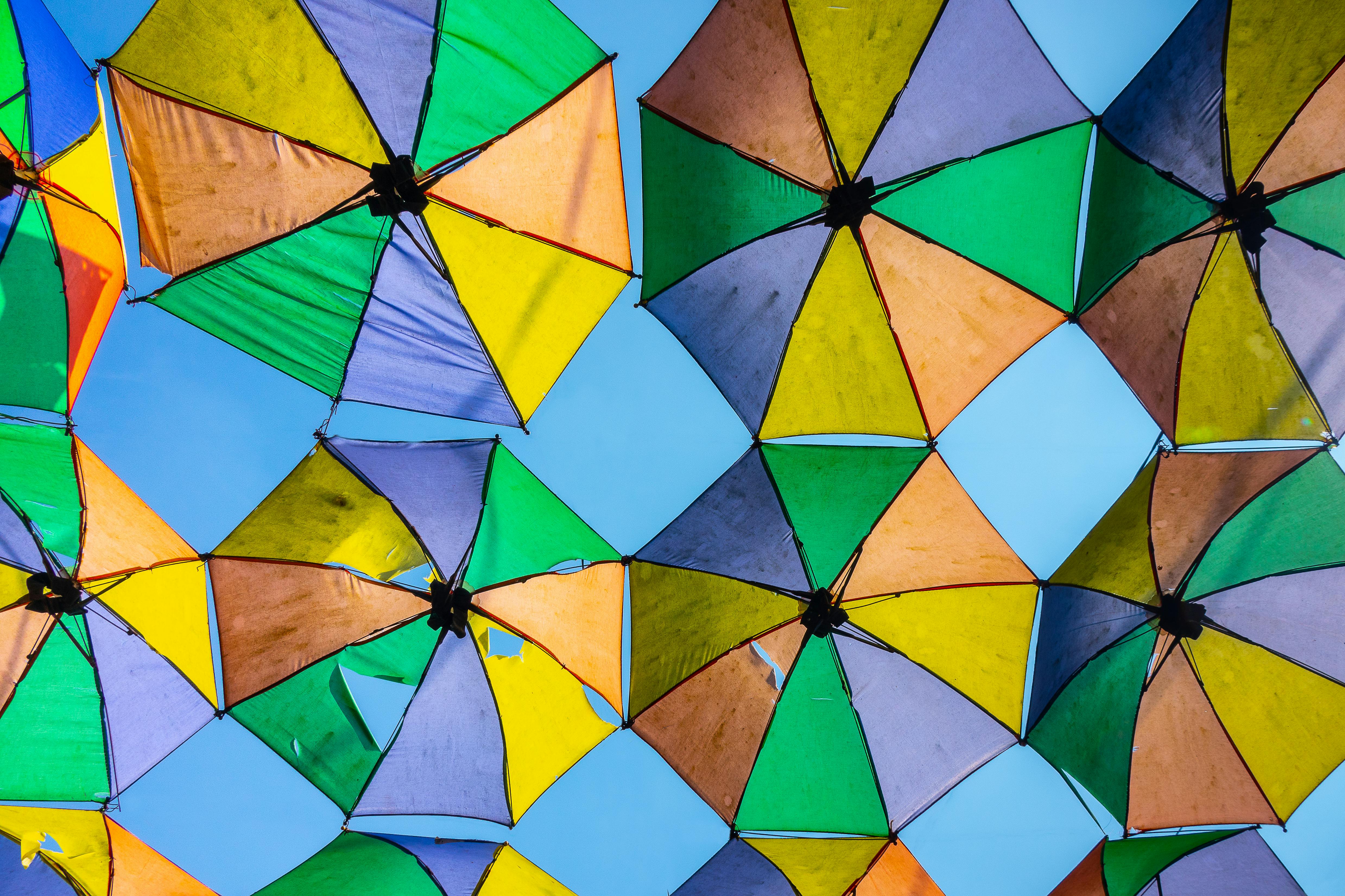 Full Shot of Tattered Umbrellas Hanged Against Blue Sky · Free Stock Photo