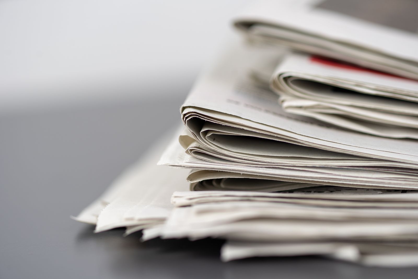 Close-up of a folded stack of newspapers on a table