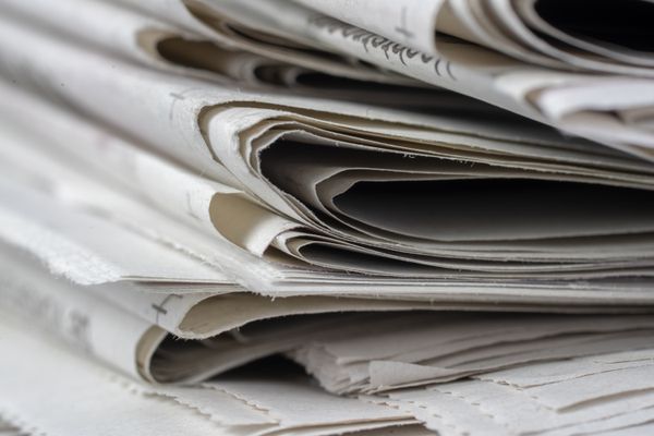 Close-up of folded newspapers stacked edge on — Mike van Schoonderwalt on Pexels