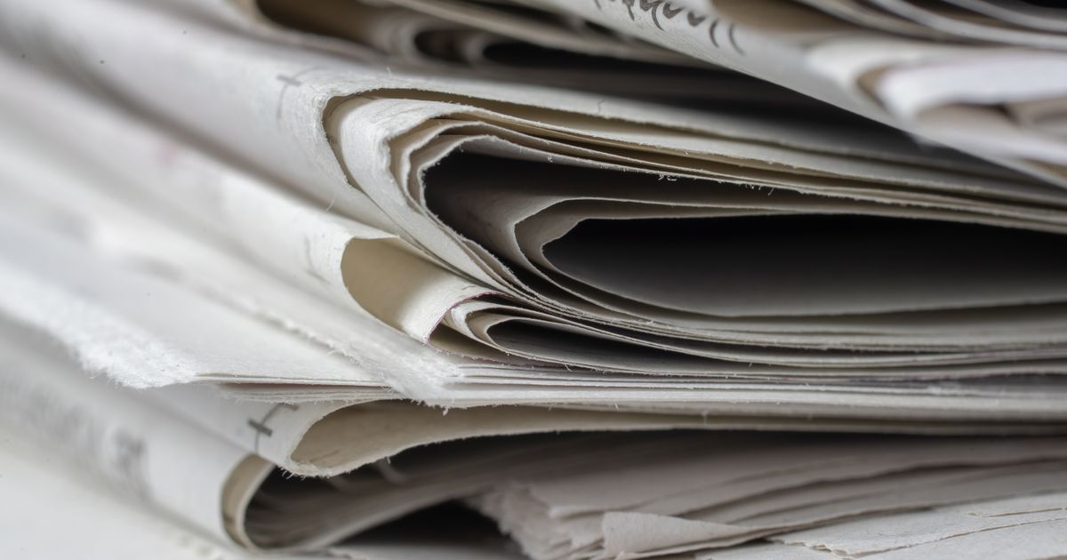 Une pile de journaux imprimés vue de près, les pages superposées.