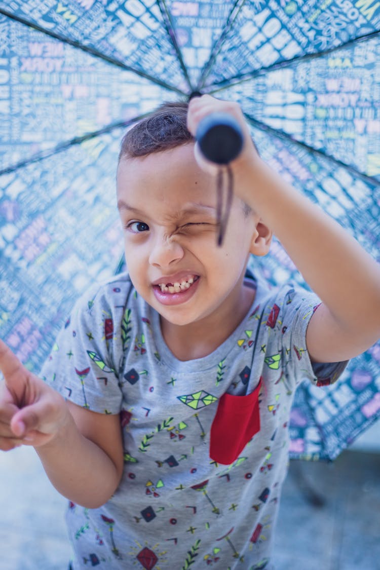 Cute Boy Holding A Blue Umbrella