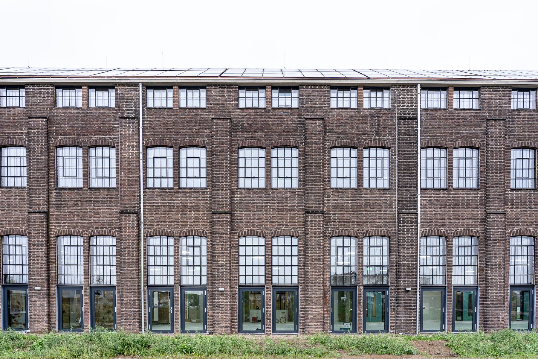Symmetrical brick warehouse facade with large steel-framed windows, typical of Dogpatch's shipyard-era buildings