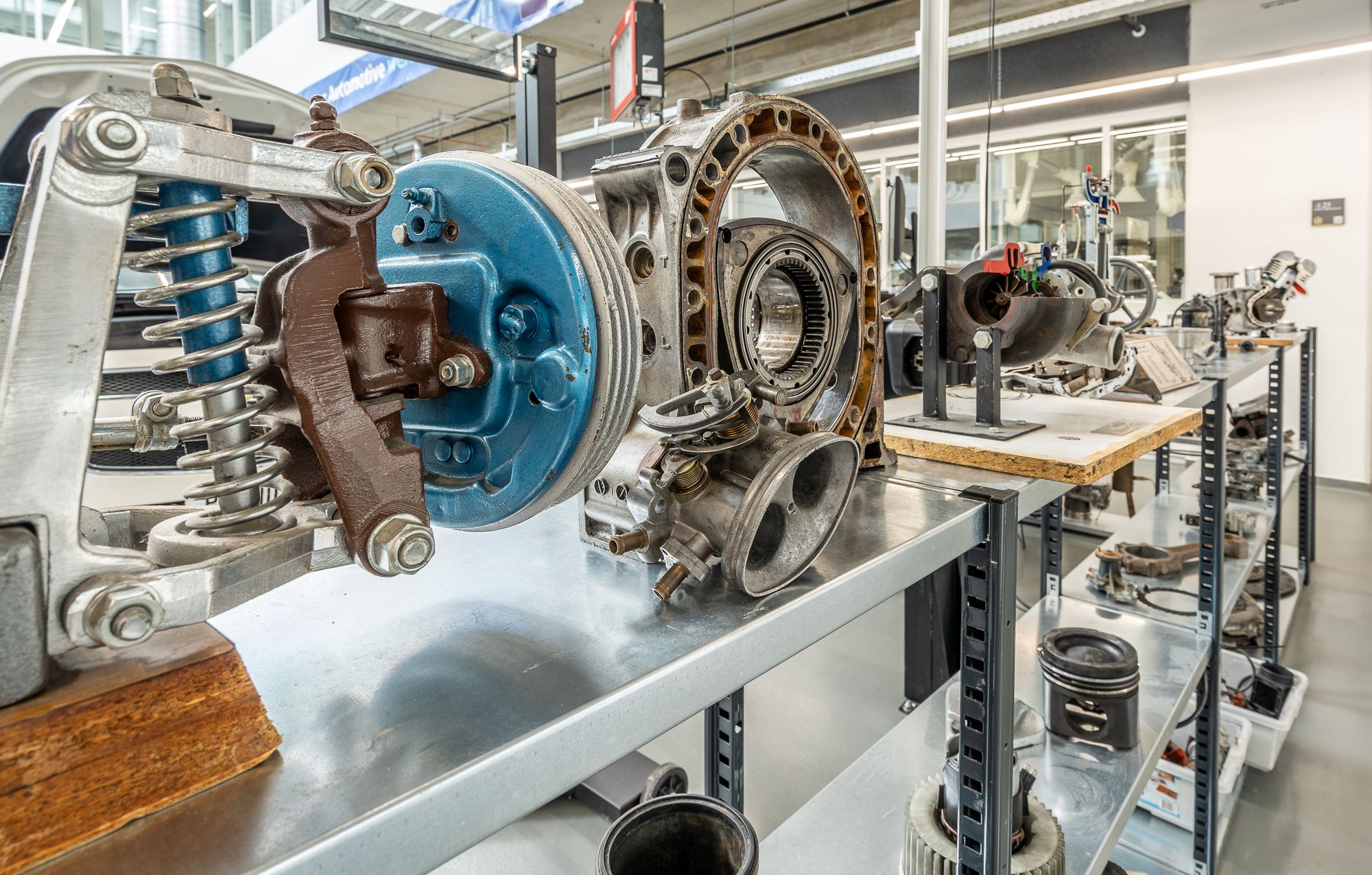 Shows disassembled rotary engine housing components on a display bench, directly illustrating Wankel engine internals.
