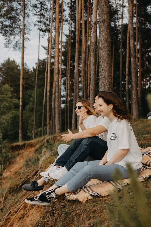 Friends Sitting on a Blanket in the Forest Together