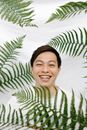 一个开朗的男人在生机勃勃的绿色蕨类植物中微笑，展现着欢乐与自然之美