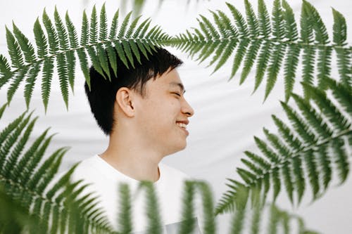Smiling Man near Green Plants