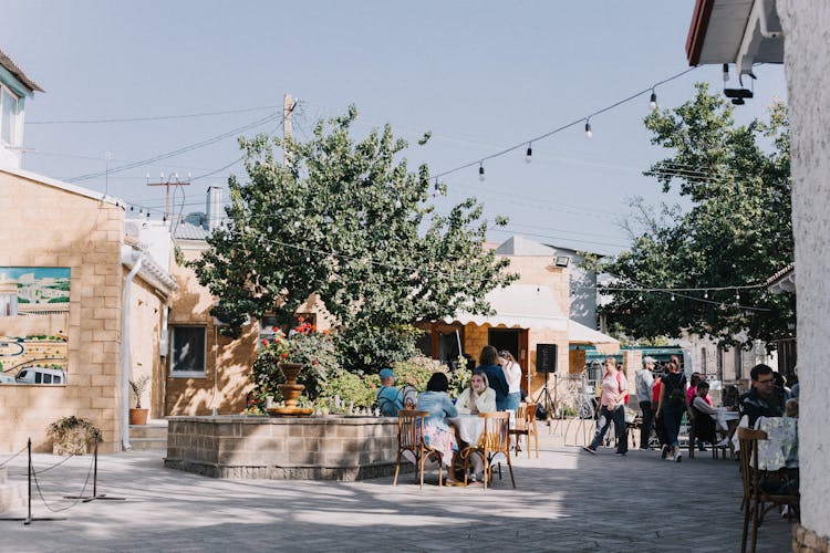 People Sitting In Cafes On City Street