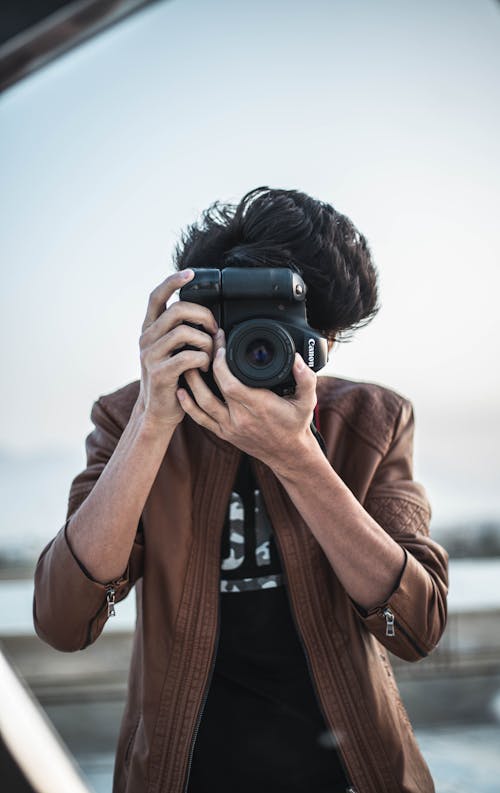 A Man in Brown Jacket Holding a Black Camera