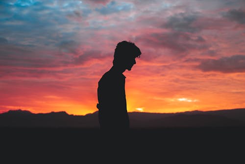 Silhouette of Man Standing during Sunset