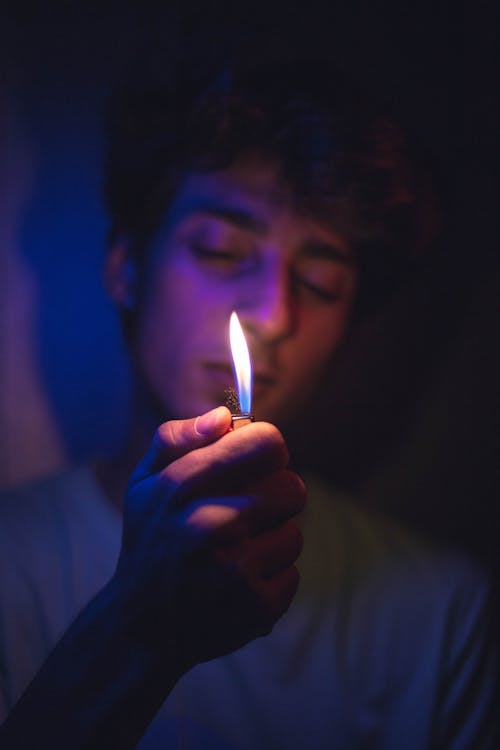 Free Man Holding a Lighter on His Hand Stock Photo