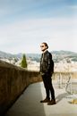 Man in Black Jacket Standing on Gray Concrete Pathway