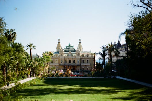 View of Monte Carlo Casino in Monaco surrounded by lush greenery, a renowned tourist attraction.