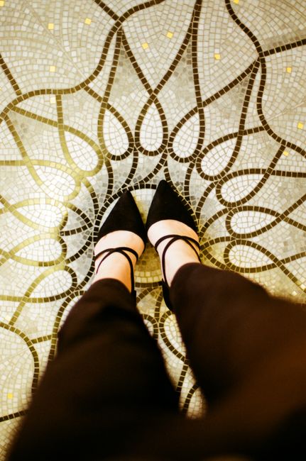 Stylish black heels on an artistic mosaic floor in Monaco, creating a fashion-forward statement.