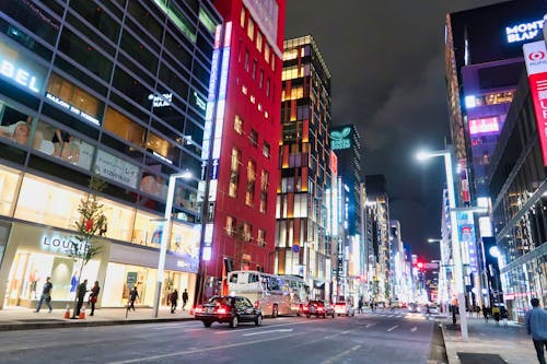 Moving Cars on the Road Between High Rise Buildings during Night Time