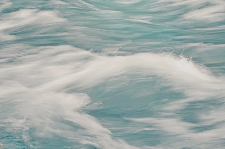 Abstract background of clear waves of sea rolling fast creating white foam in motion