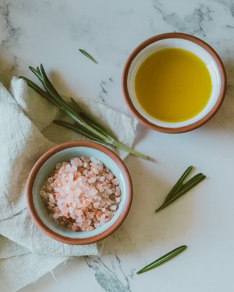 Bowls Of Herbs And Spices On A White Surface