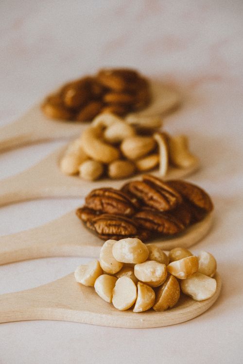 Free Close-up of assorted nuts on wooden spoons, highlighting variety and nutrition. Stock Photo