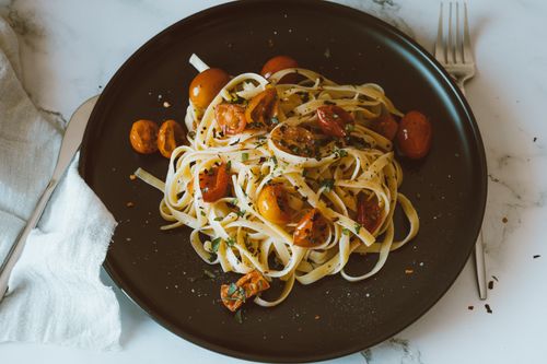 Free Savor a classic Italian pasta dish featuring linguine with roasted cherry tomatoes, perfect for a healthy meal. Stock Photo