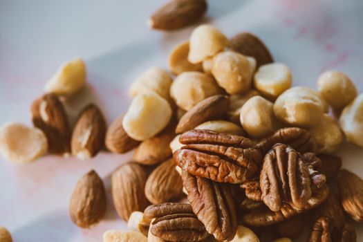 A close-up image showcasing a variety of mixed nuts including almonds, pecans, and macadamias.
