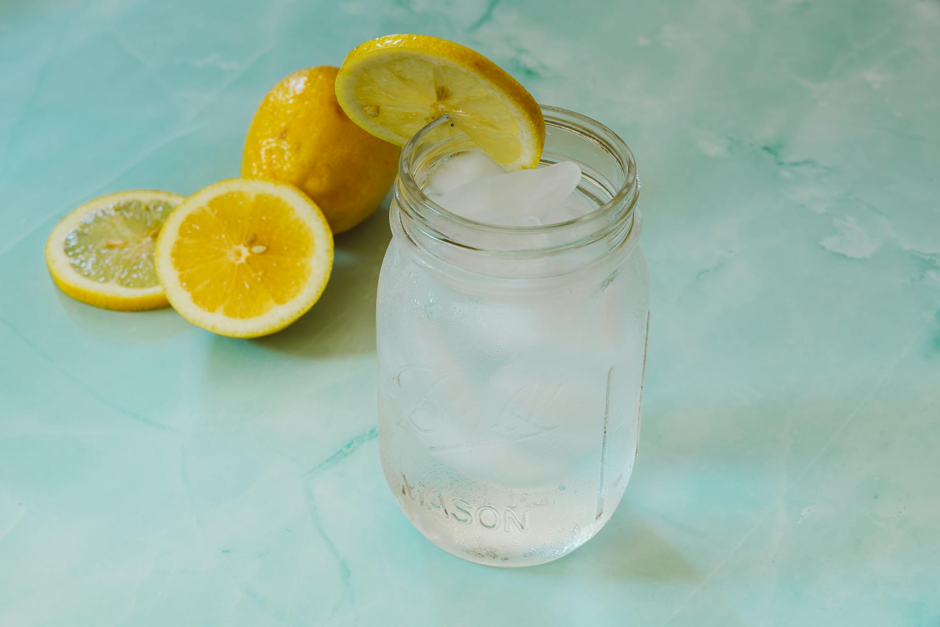 Chilled lemonade in a mason jar with lemon slices and ice cubes, perfect for summer.