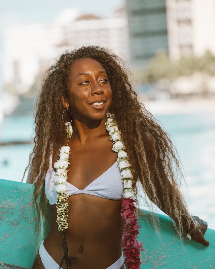 A Woman In White Bikini Wearing A Lei 
