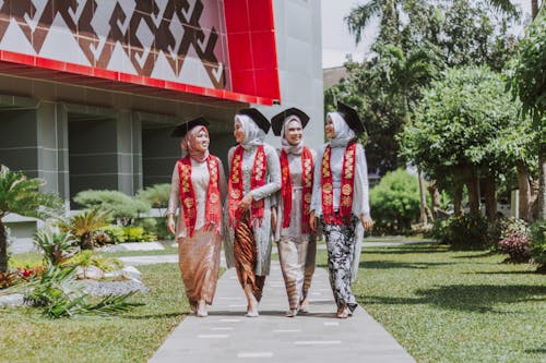 3 Women Standing on Gray Concrete Pathway