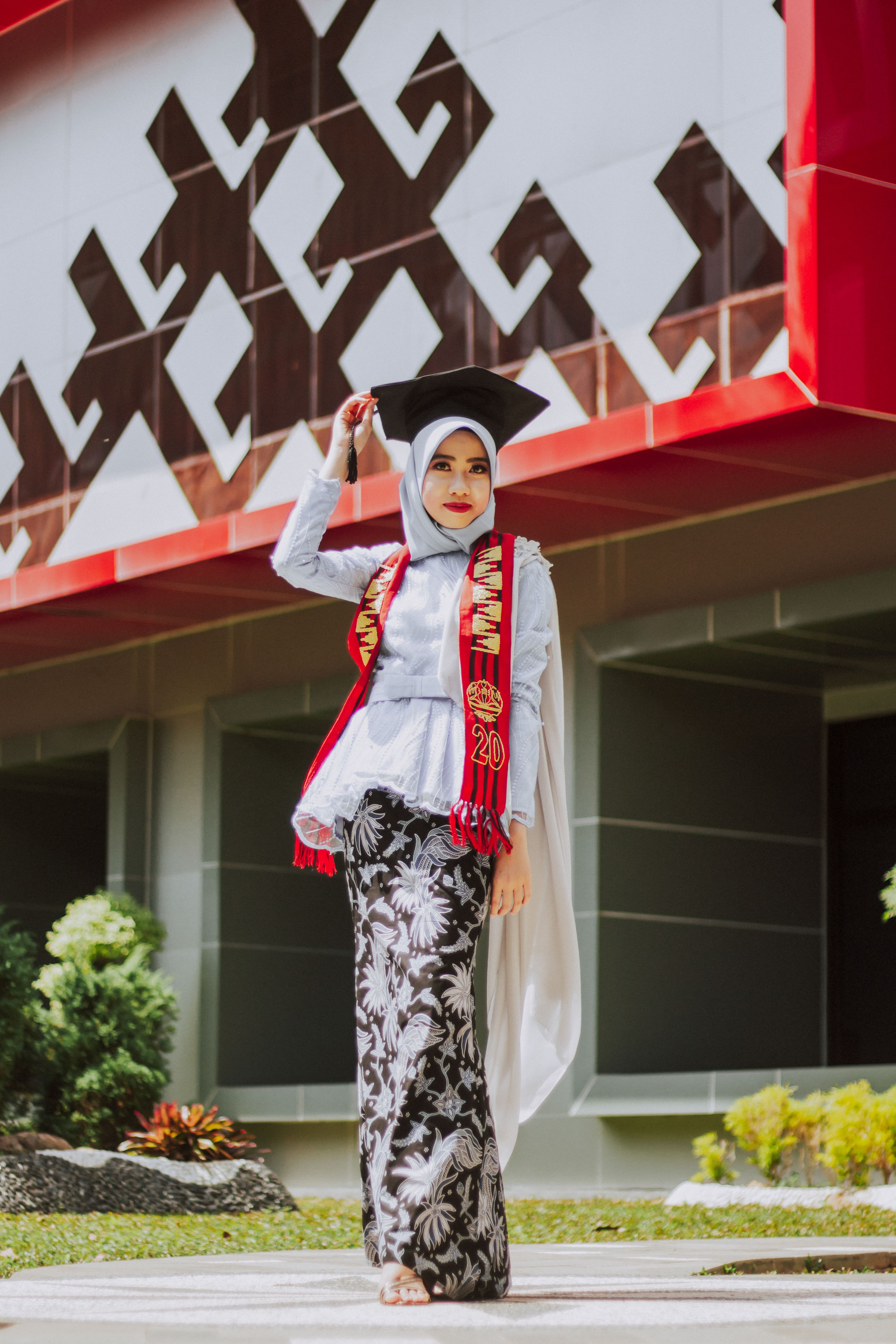 Woman in Red Dress and Hijab Wearing Graduation Gown · Free Stock Photo