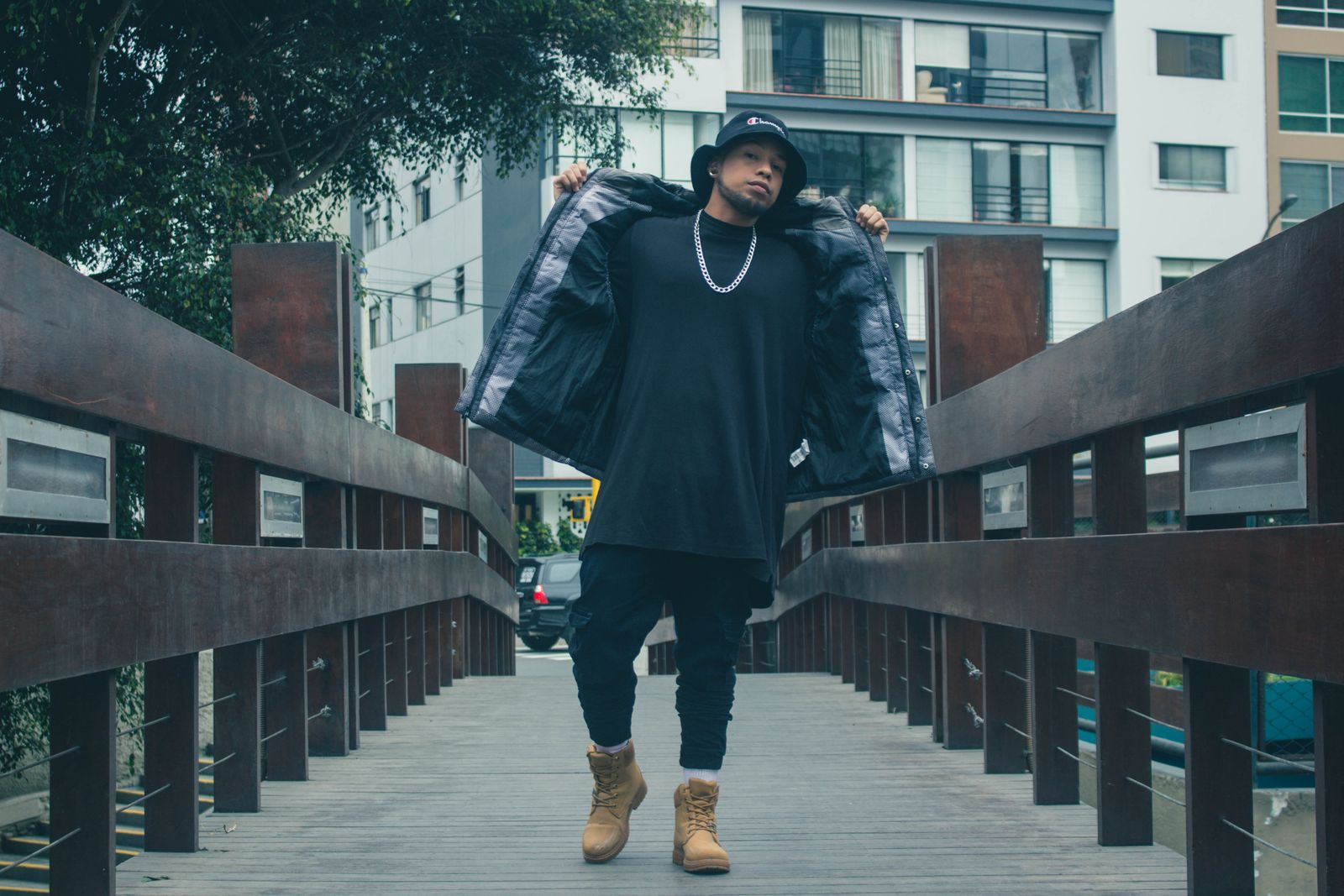 Stylish man in urban streetwear on city bridge