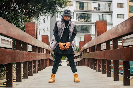 Young man in urban fashion posing confidently on a wooden bridge outdoors.