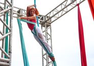 Woman in Purple Tank Top and White Pants Climbing on Blue Ladder