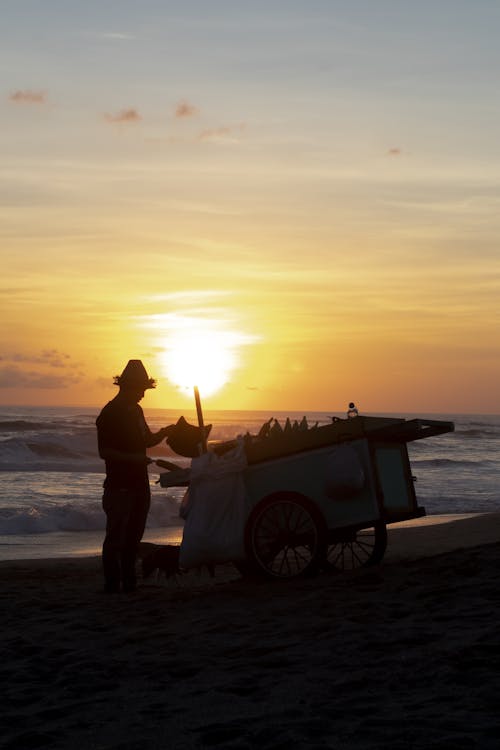 A Man Standing by the Sea at Sunset