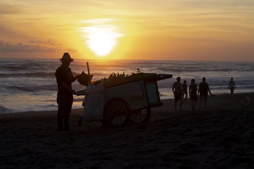 Free People on a Beach at Sunset Stock Photo