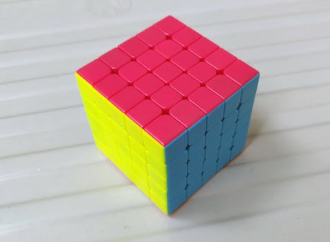 A vibrant 4x4 puzzle cube showcasing red, yellow, and blue colors on a white background, perfect for mind training concepts.
