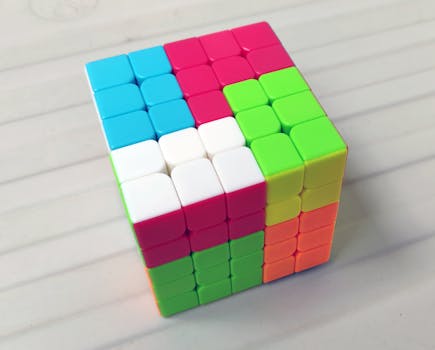 A vibrant Rubik's Cube with mixed colors on a white surface, showcasing complexity and puzzle-solving.