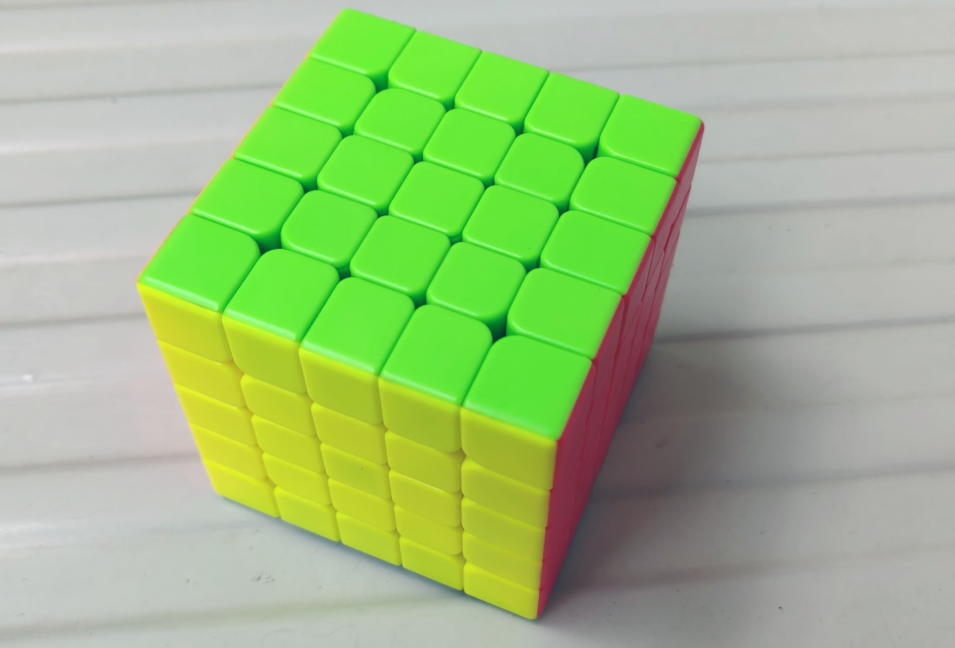 A 5x5 Rubik Cube Puzzle on White Table