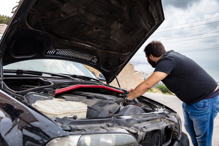 A Man Checking A Car's Engine