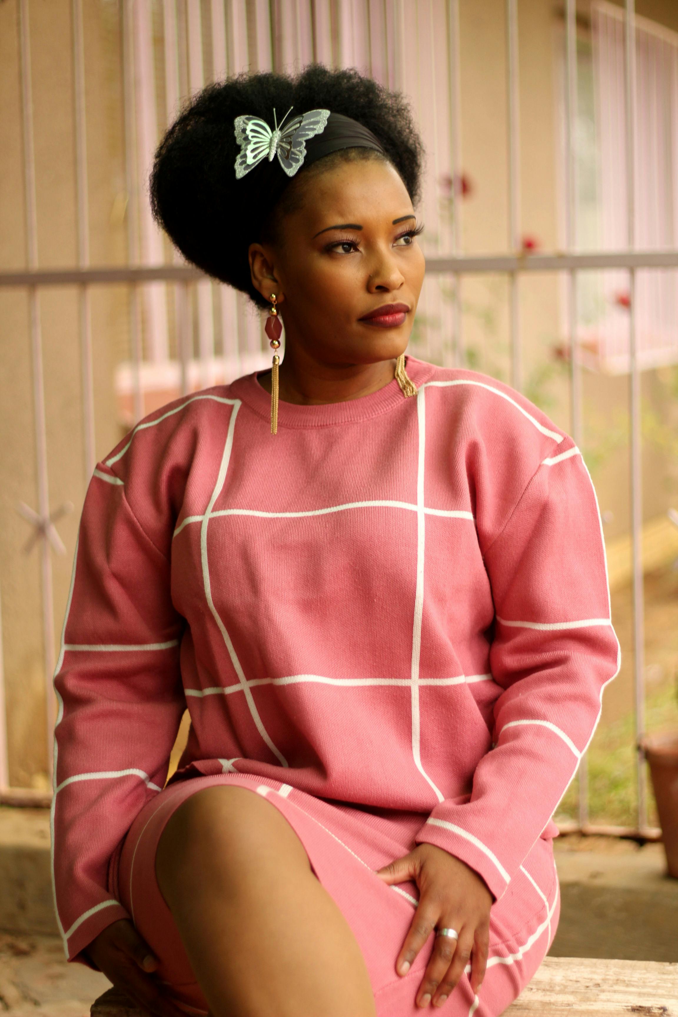 White Dog in Orange Raincoat Sitting on the Pavement · Free Stock Photo