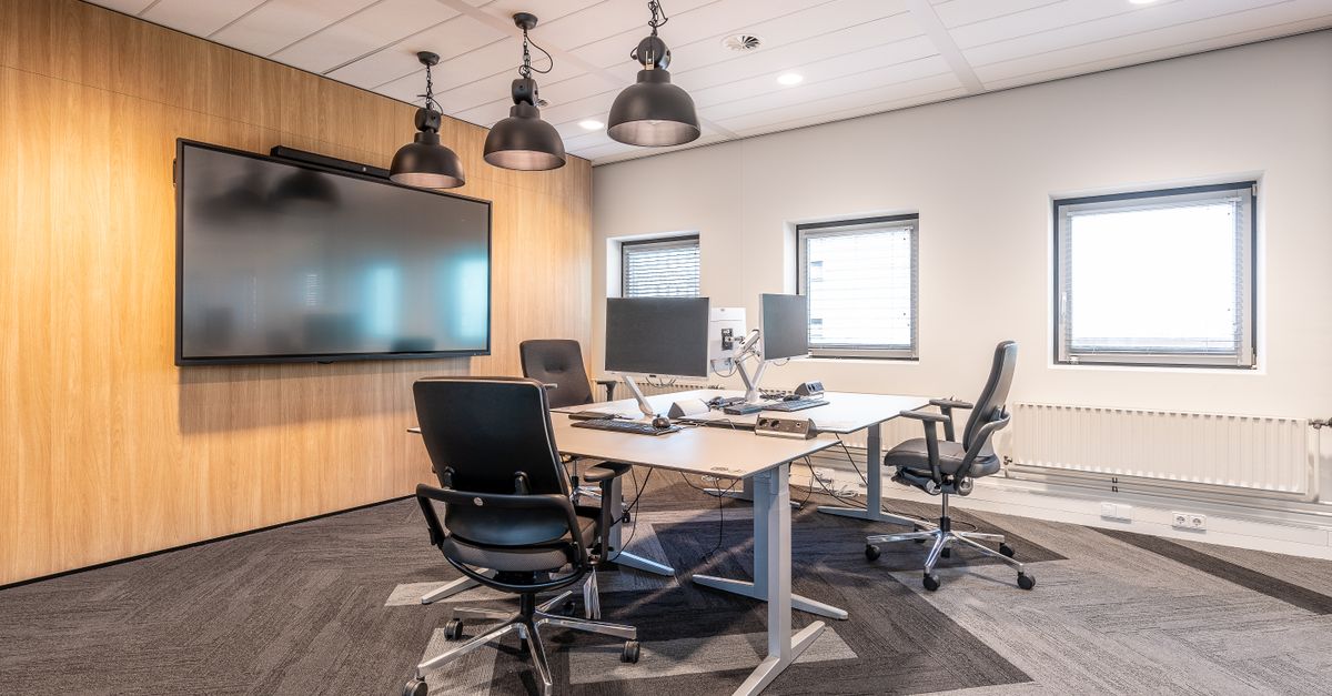 Spacious, well-lit office conference room featuring modern computers and a large screen display for presentations.