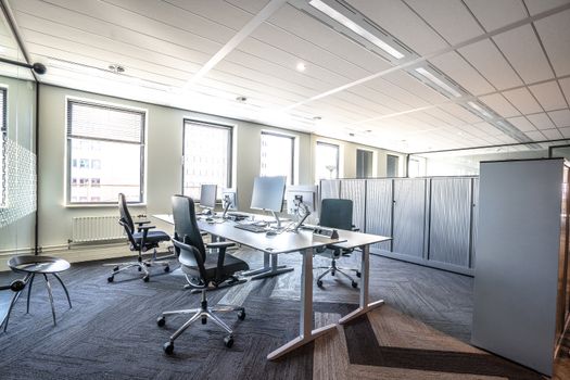 Bright and spacious modern office interior featuring sleek workstations and ergonomic chairs.